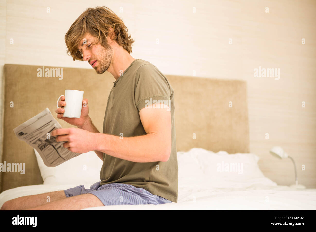 Gut aussehender Mann die Nachricht lesen und Kaffee trinken Stockfoto