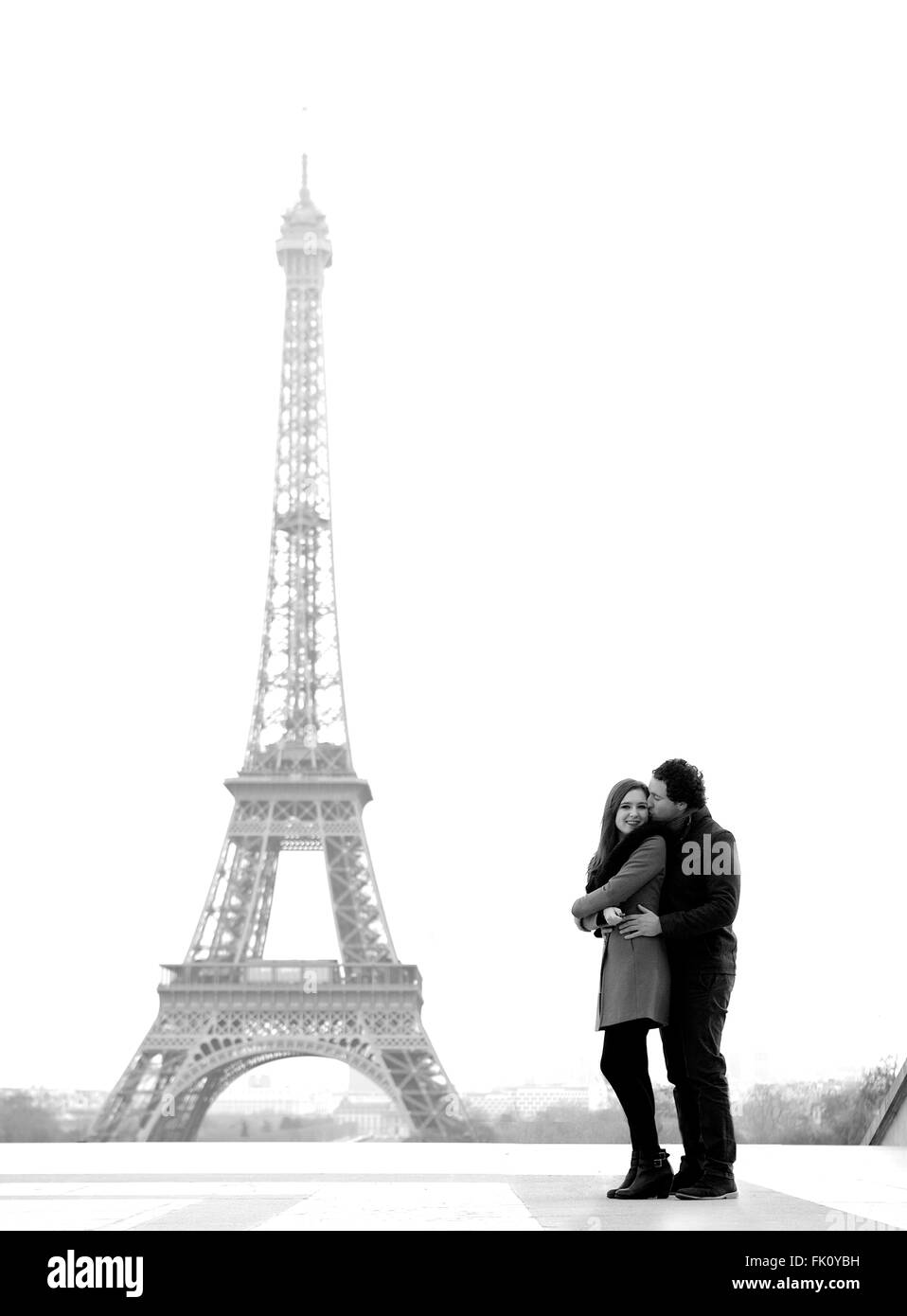 Jung und in Liebe Brünette Pärchen vor Eiffelturm, Paris, Trocadero mit Blick auf die Stadt während des Tages - umarmt Stockfoto