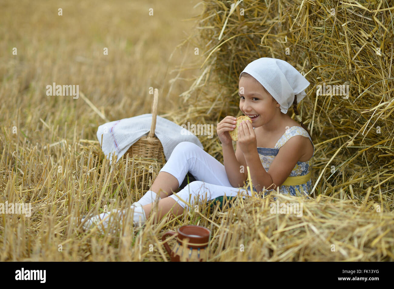 Mädchen mit Milch und Krapfen in Feld Stockfoto