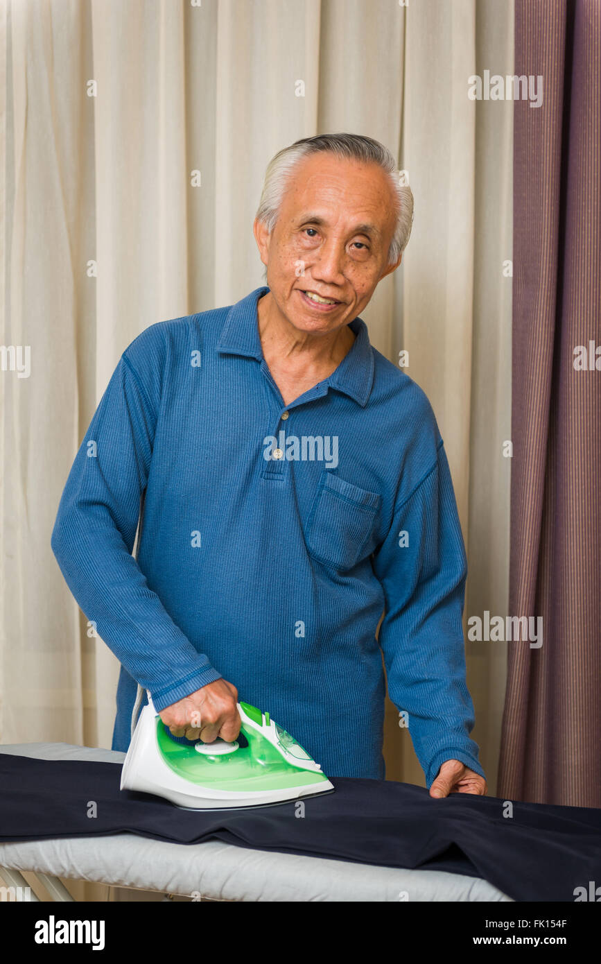 Glücklich senior asiatischen Mann Hausarbeit zu genießen. Stockfoto