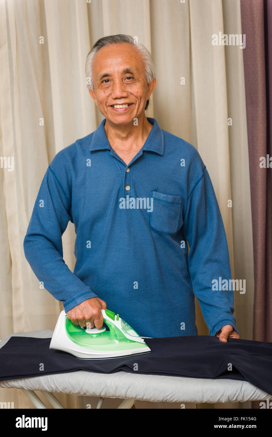 Glücklich senior asiatischen Mann Hausarbeit zu genießen. Stockfoto