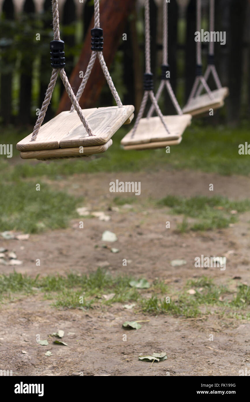 Vertikale Perspektive von drei hölzernen Kind Schaukeln im Park mit geringen Schärfentiefe Stockfoto
