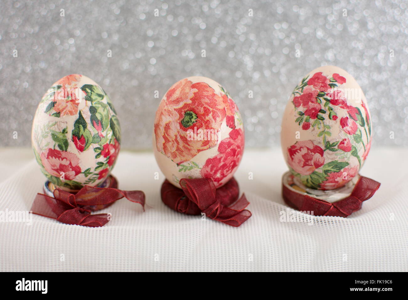 Bunte hausgemachte Serviettentechnik verziert Ostereier glänzend Silber Hintergrund Stockfoto