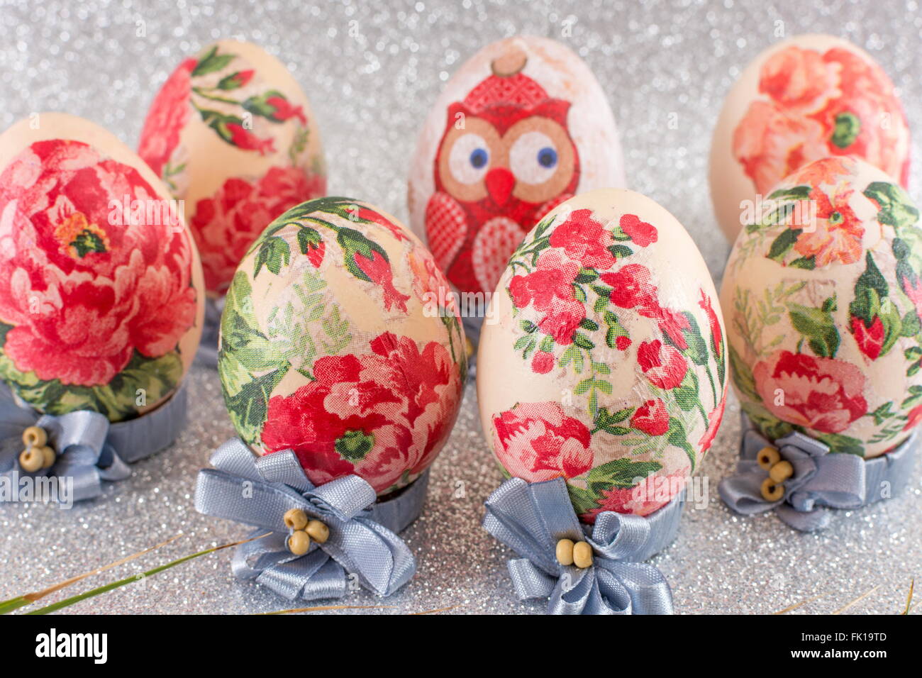Bunte hausgemachte Serviettentechnik verziert Ostereier glänzend Silber Hintergrund Stockfoto