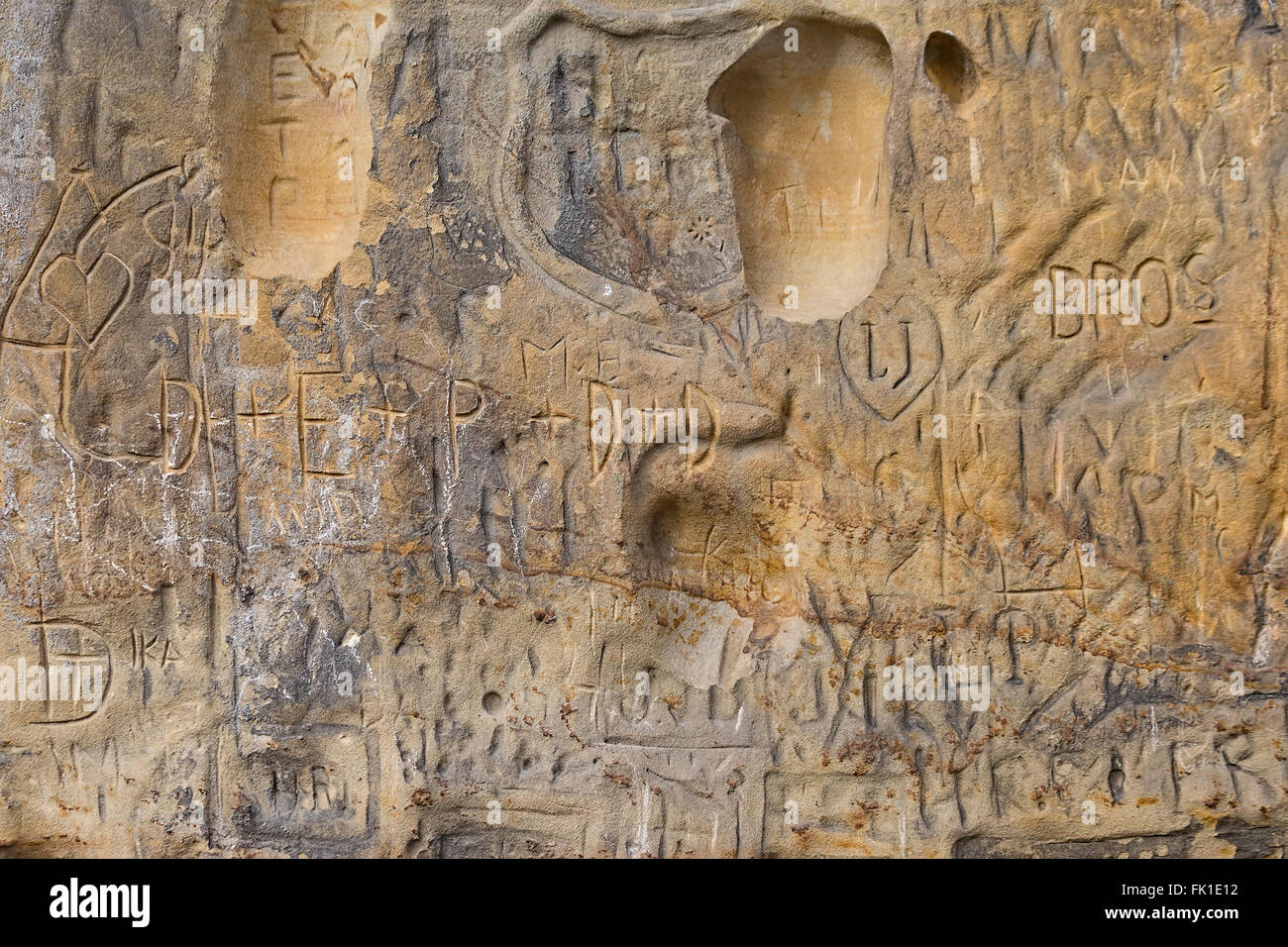 Alten Sandsteinwand oder Rock mit alten Schreibweise von vielen namenlosen Menschen Stockfoto