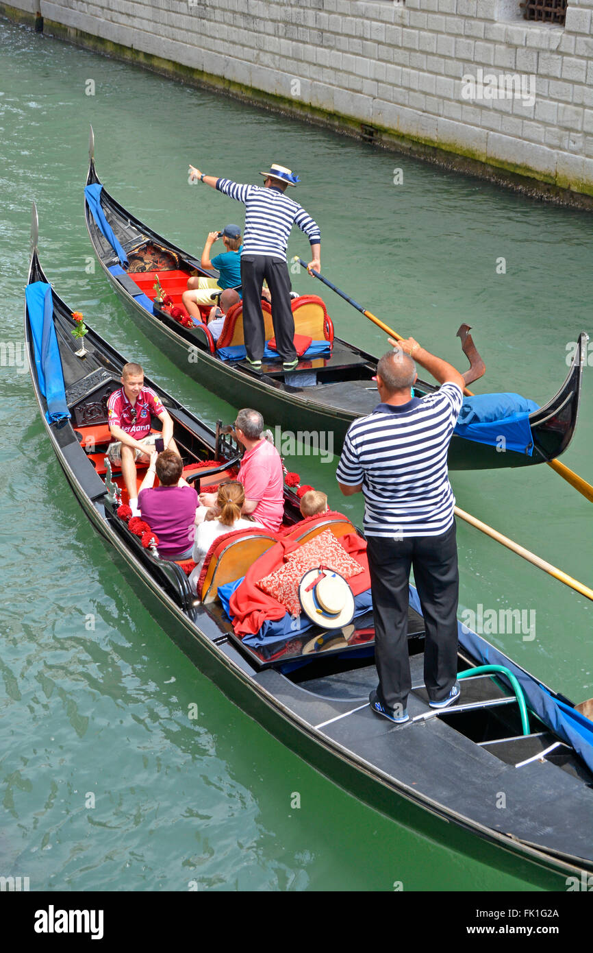 Venedig Gondel Familie Gruppe von Touristen auf Besichtigungstour Fahrt entlang des engen Kanals mit Gondoliere zeigt auf Sehenswürdigkeiten von Interesse zwei von einer Art Italien Stockfoto