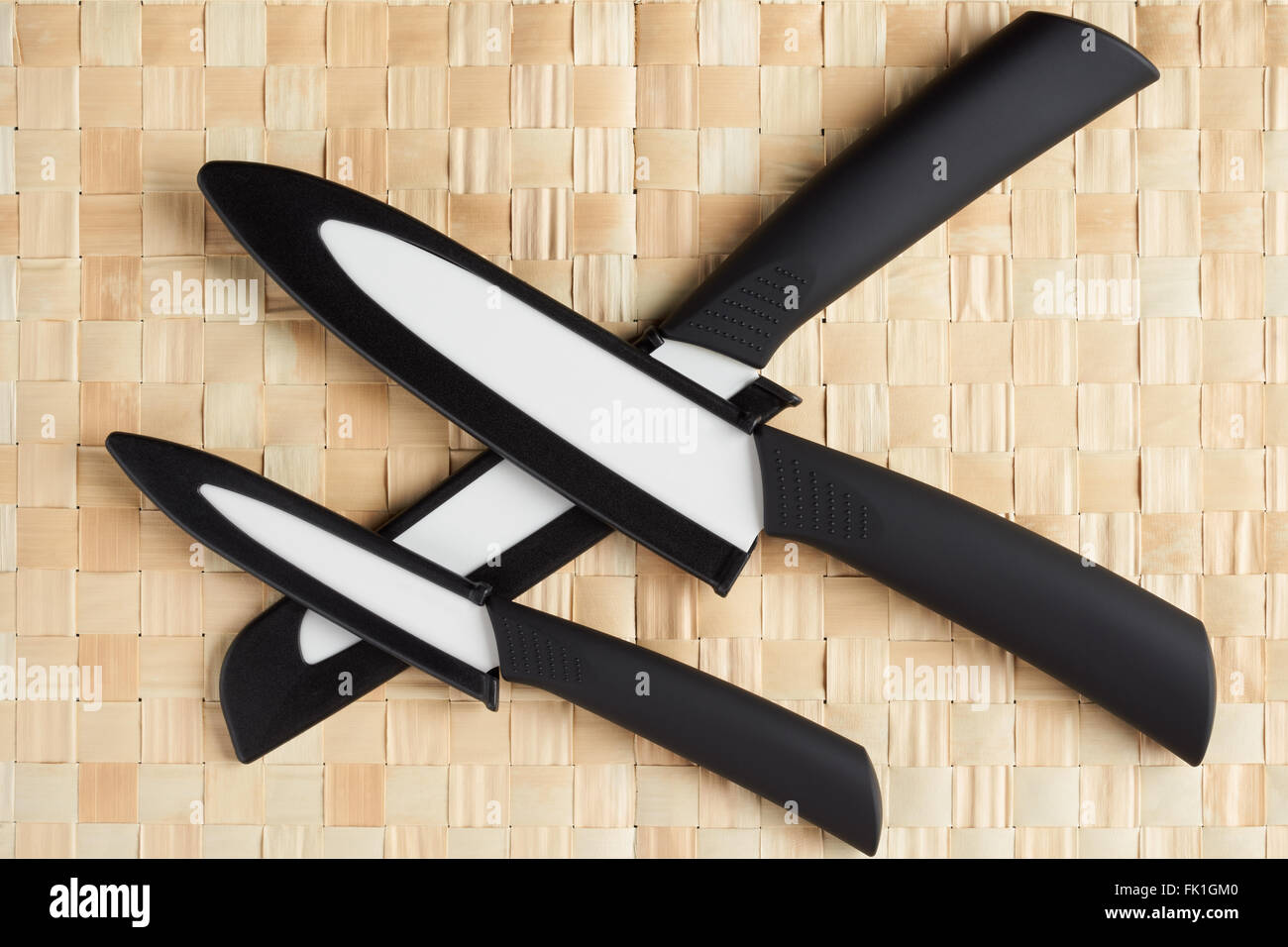 Drei weiße Keramik Messer in schwarze Abdeckung auf Bambus Serviette Stockfoto