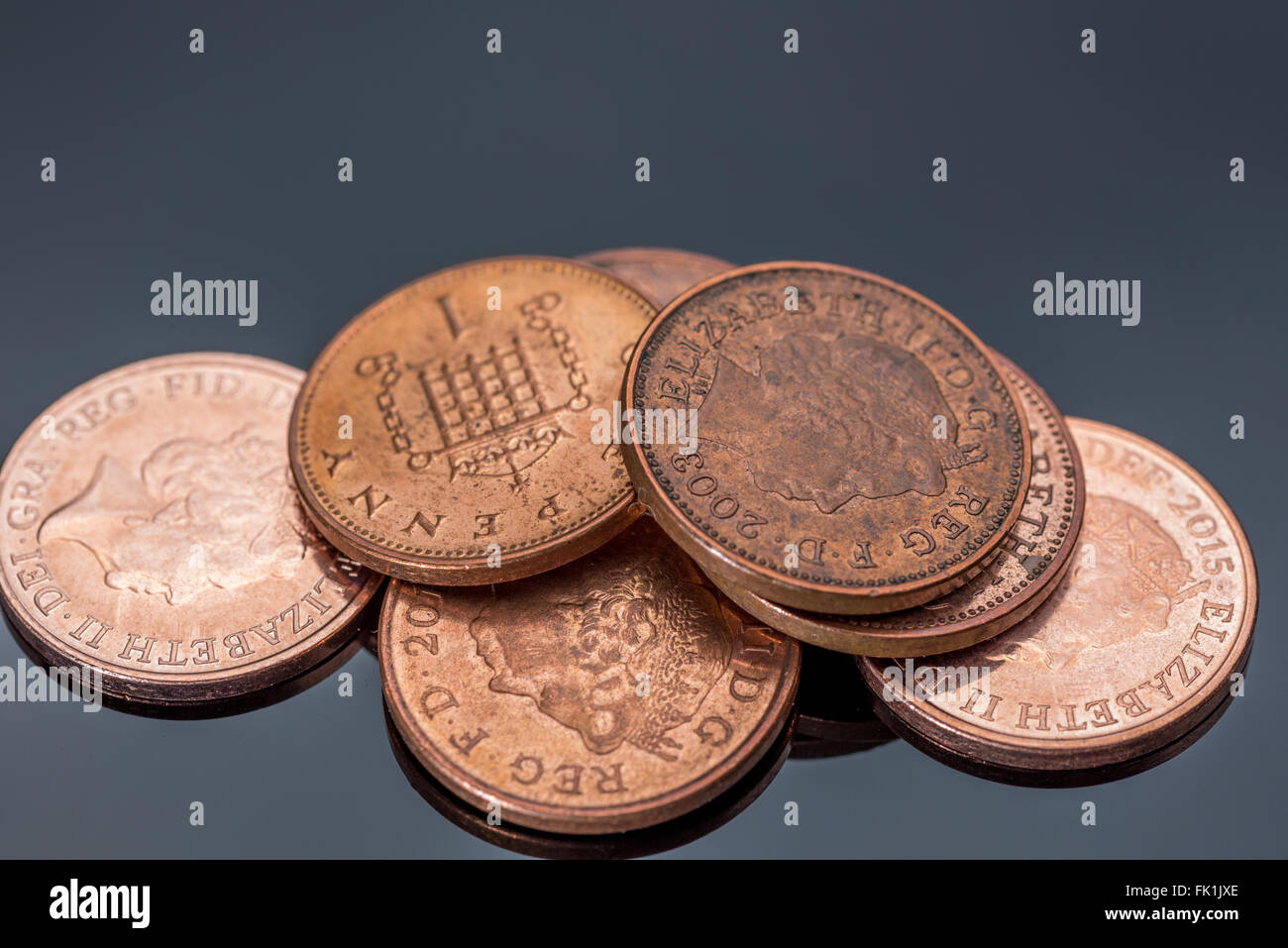 Ein Haufen von Penny-Münzen vor schwarzem Hintergrund Stockfoto