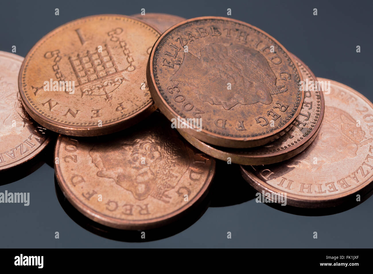 Ein Haufen von Penny-Münzen vor schwarzem Hintergrund Stockfoto