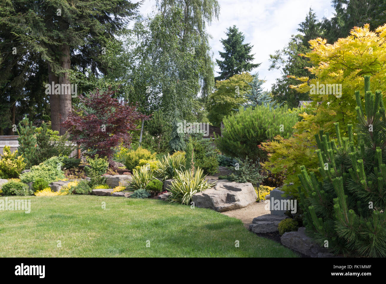 Gestaltete flache Felsen aus Nordwesten Oregon befinden sich natürlich in einem wunderschön angelegten Garten unter einer Vielzahl von pro Stockfoto