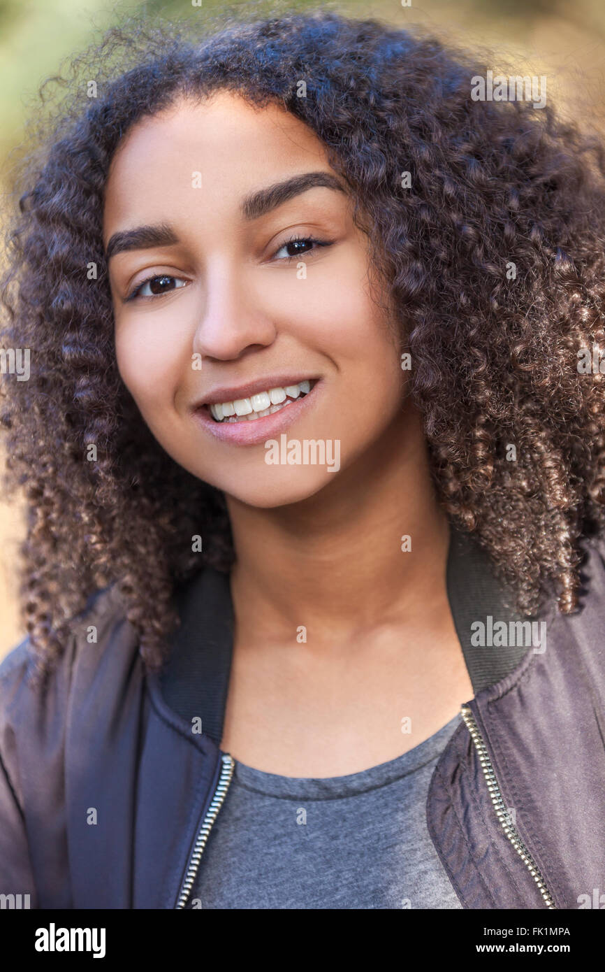 Outdoor Portrait der schönen glücklich gemischt Rennen afroamerikanische Mädchen Teenager weibliche junge Frau Lächeln mit perfekten Zähnen Stockfoto