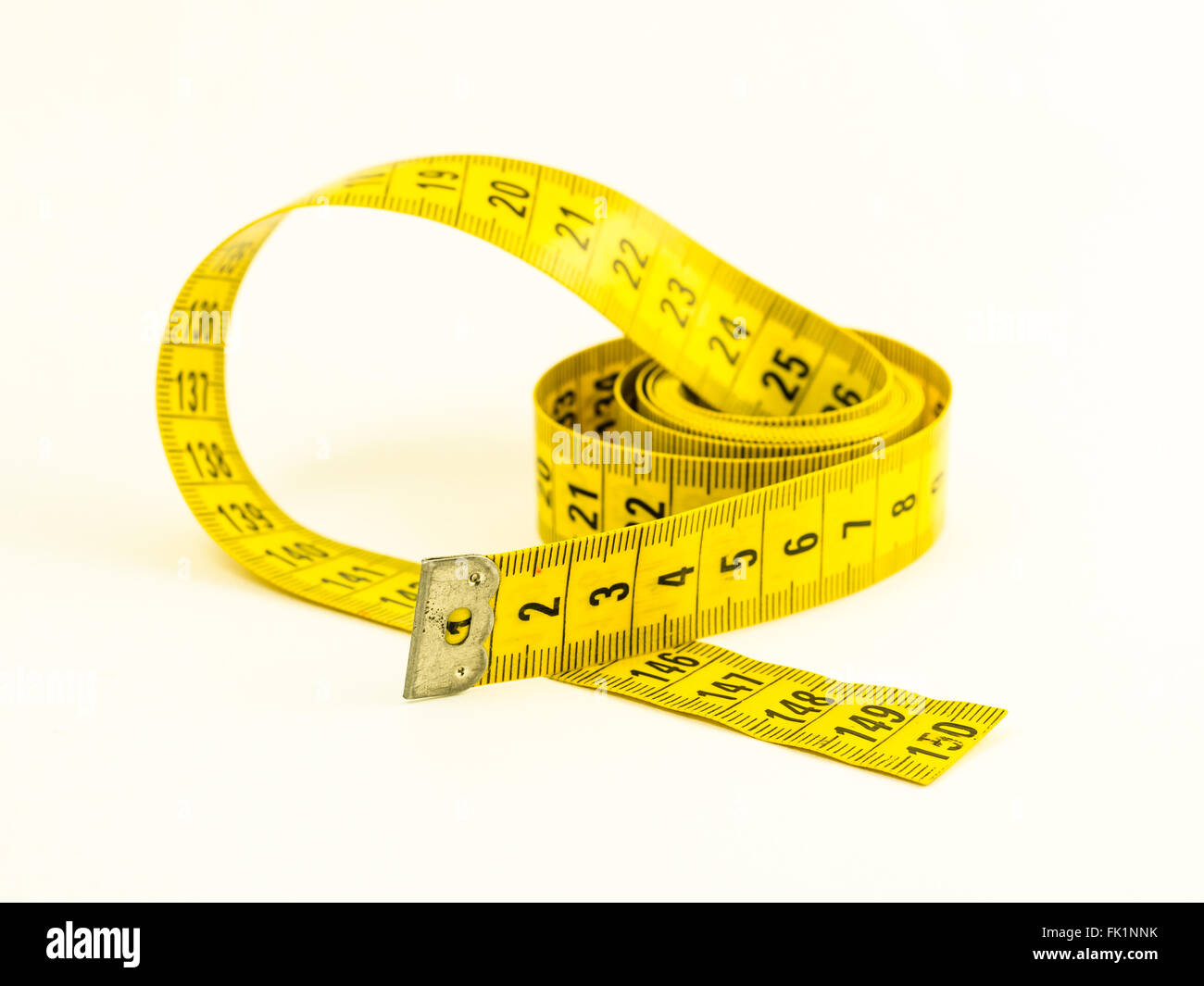 Stillleben mit einem gelben Maßband und Bleistift, über weiß Stockfoto