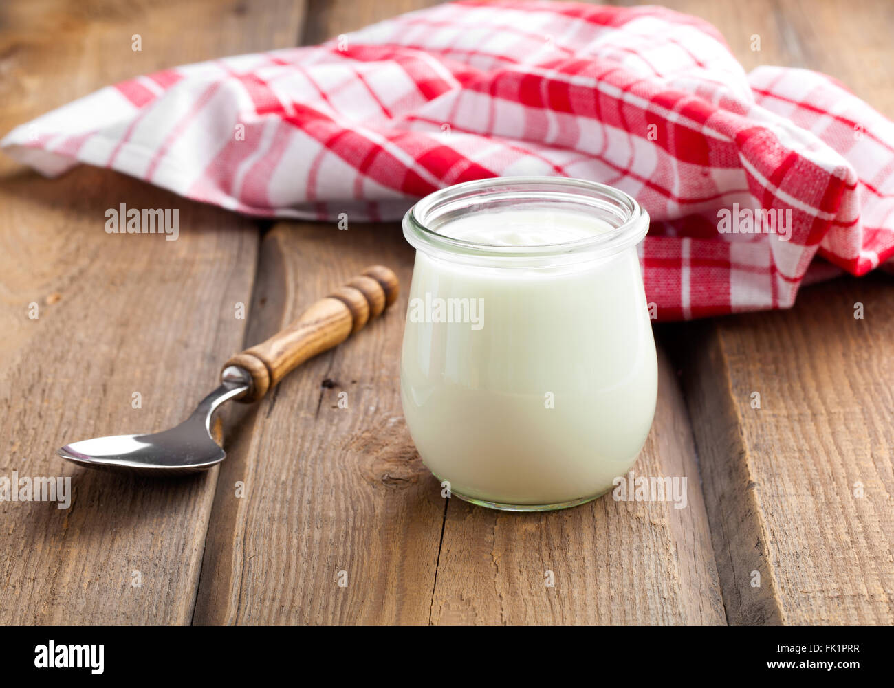 Lecker, nahrhaft und gesund Joghurt in einem Glas Gläser mit Löffel auf hölzernen Hintergrund Stockfoto