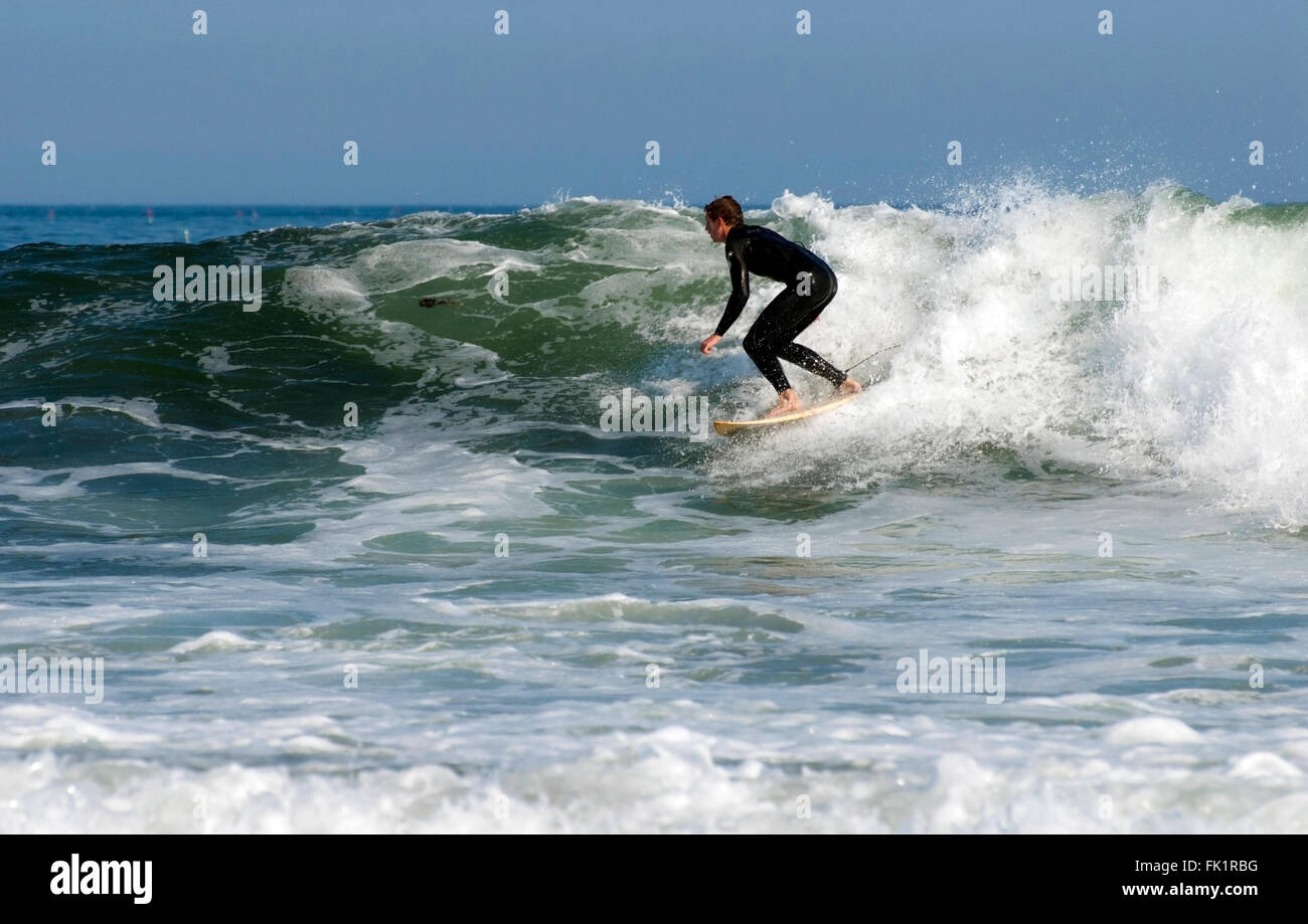 Surfer tragen einen Taucheranzug ist Reiten die Wellen an der Küste von New Hampshire im kalten New England Meer Wasser. Stockfoto