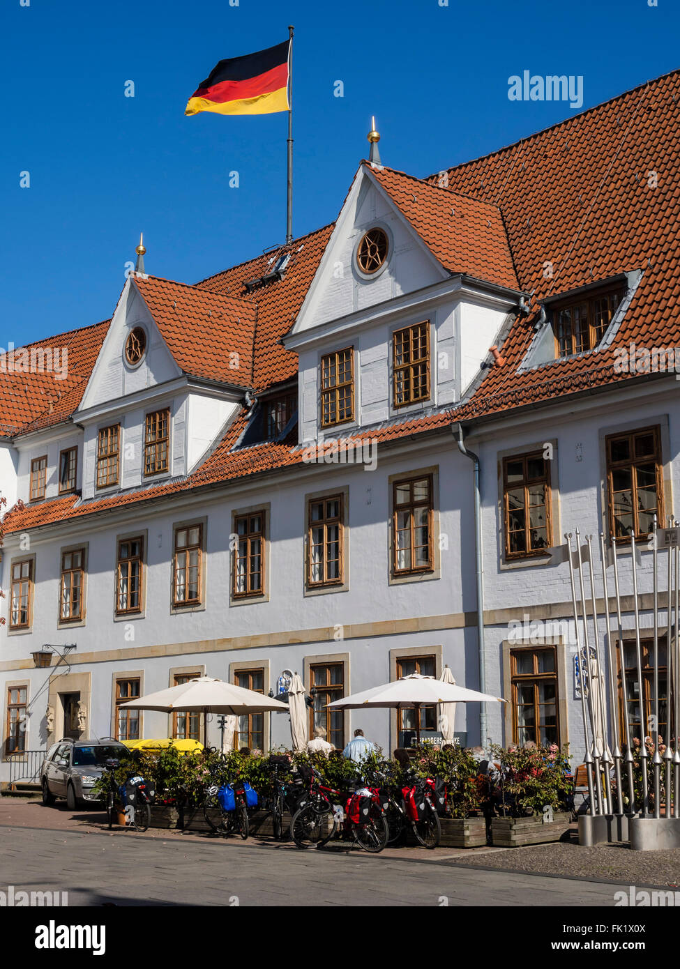 Radfahrer sitzt außerhalb des alten Rathauses, vor Restaurant, Celle, Deutschland Stockfoto