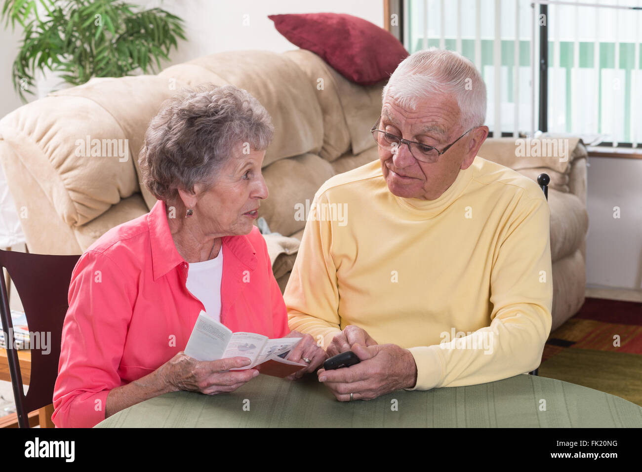 Eine Frau weist darauf hin ein Diagramm in der Anleitung für ihr neues Handy. Stockfoto