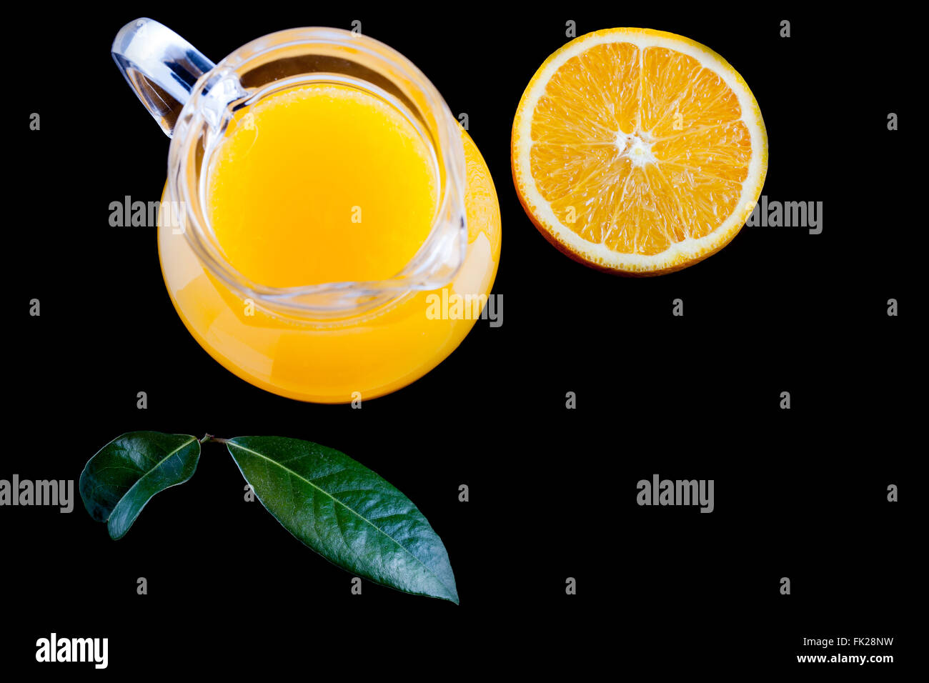 Krug mit frisch gepresstem Orangensaft auf schwarzem Hintergrund-Draufsicht Stockfoto