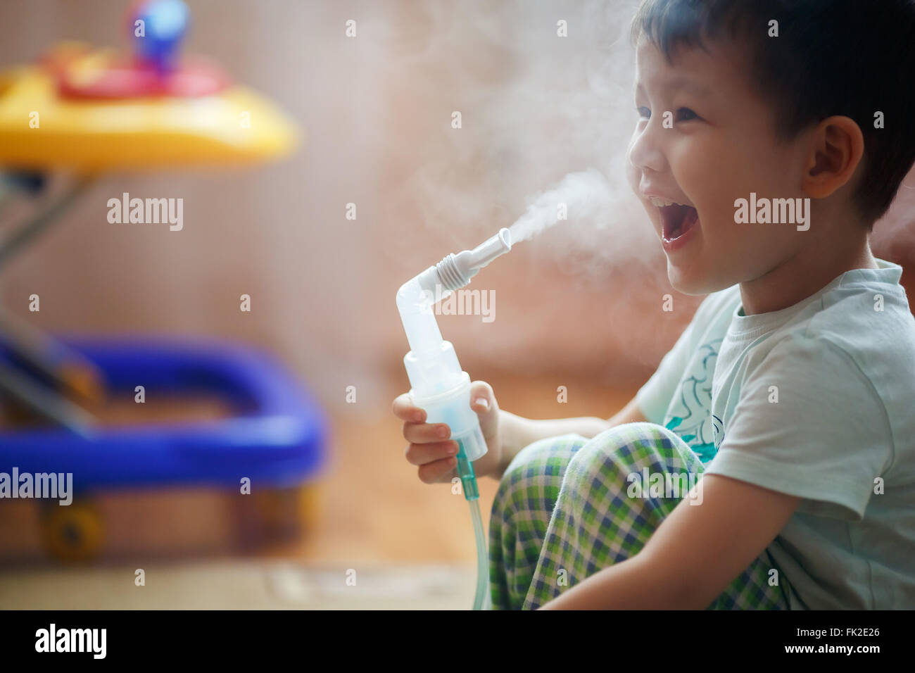 Kleiner Junge macht Inhalation zu Hause, Einnahme von Medikamenten, Bronchien. Ausatmen Dampf durch das Rohr. Stockfoto