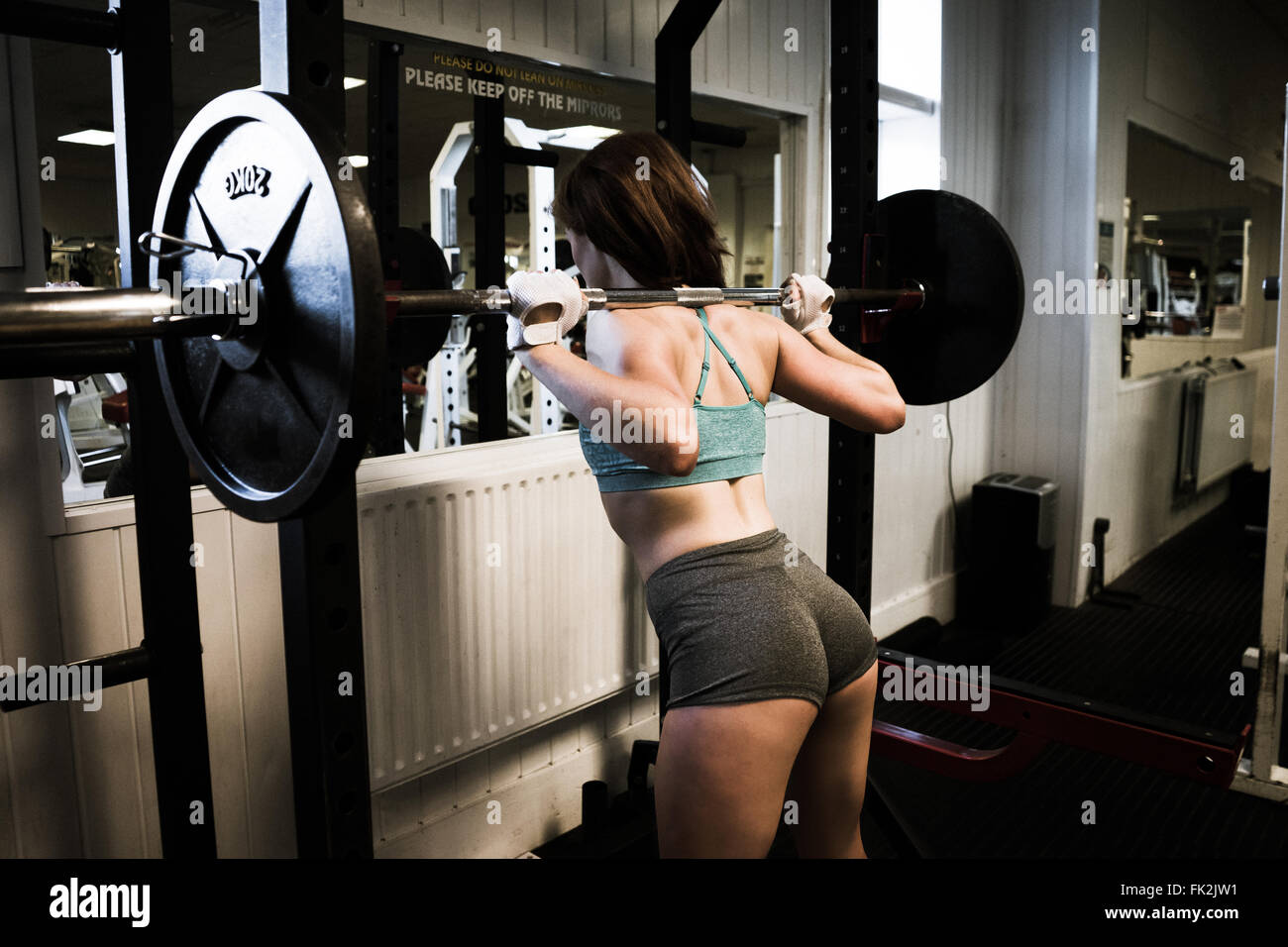 Junge und schöne Frauen Fitness Wettbewerber auf eine Zahnstange, Kniebeugen Stockfoto