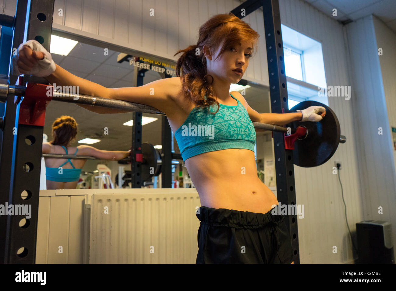 Junge und schöne Frauen Fitness Wettbewerber auf eine Zahnstange, Kniebeugen Stockfoto