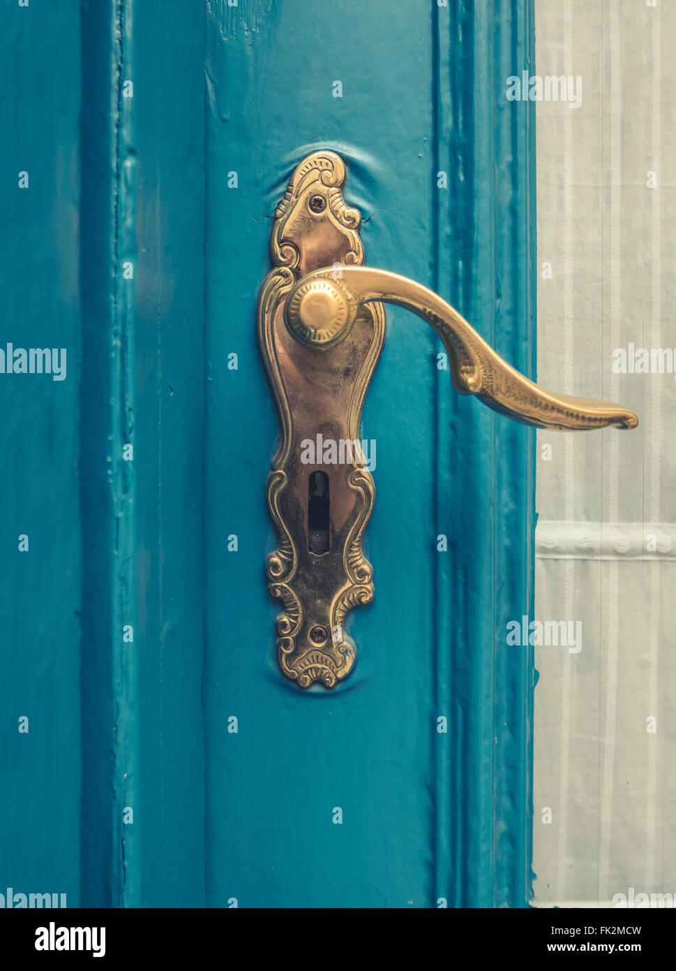 Vintage Messing Türgriff auf eine blau lackierte Tür Stockfoto