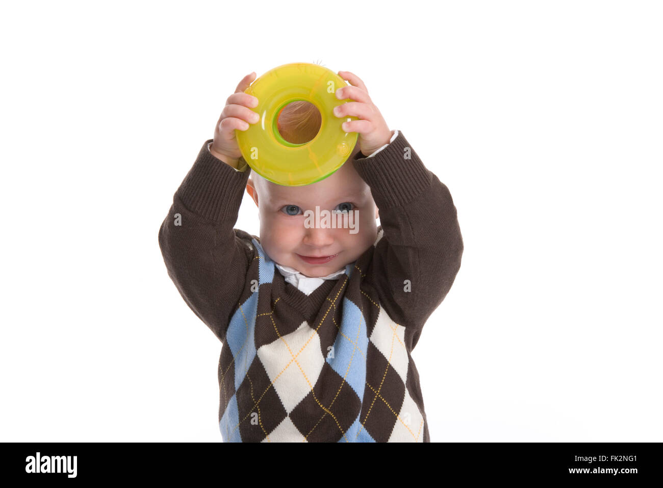 Kleinkind Boy ist zeigt A gelb Spielzeug Kunststoffring auf weißem Hintergrund Stockfoto