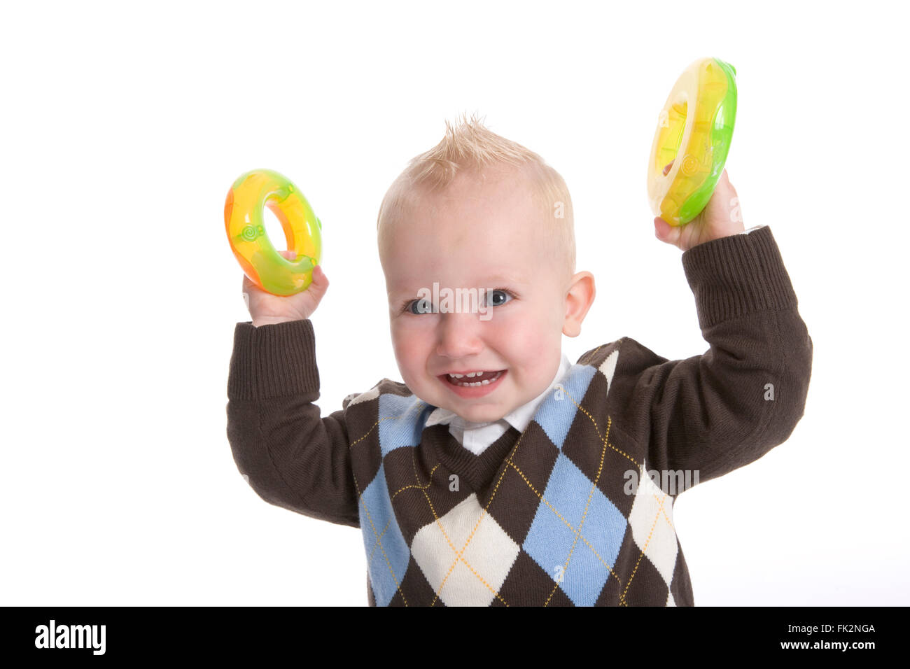 Kleinkind Boy ist zeigen, gelbe Spielzeug Kunststoffringe auf weißem Hintergrund Stockfoto