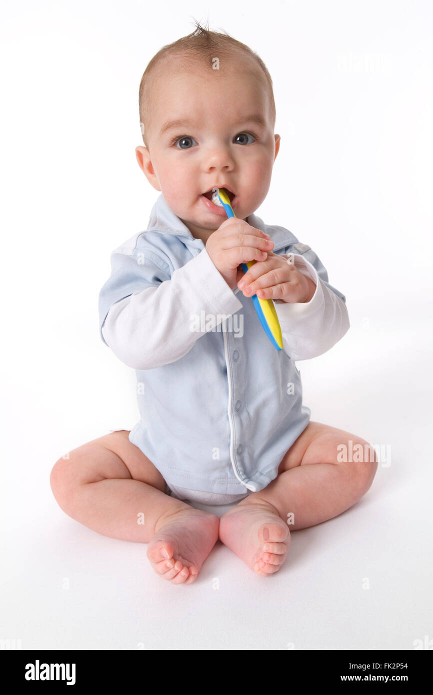 Baby Junge täuscht seine Zähne putzen auf weißem Hintergrund Stockfoto