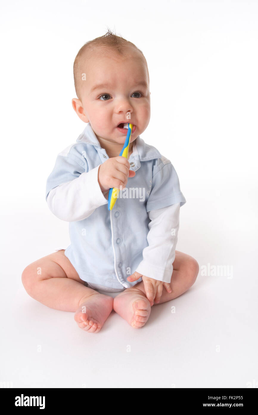 Baby Junge täuscht seine Zähne putzen auf weißem Hintergrund Stockfoto