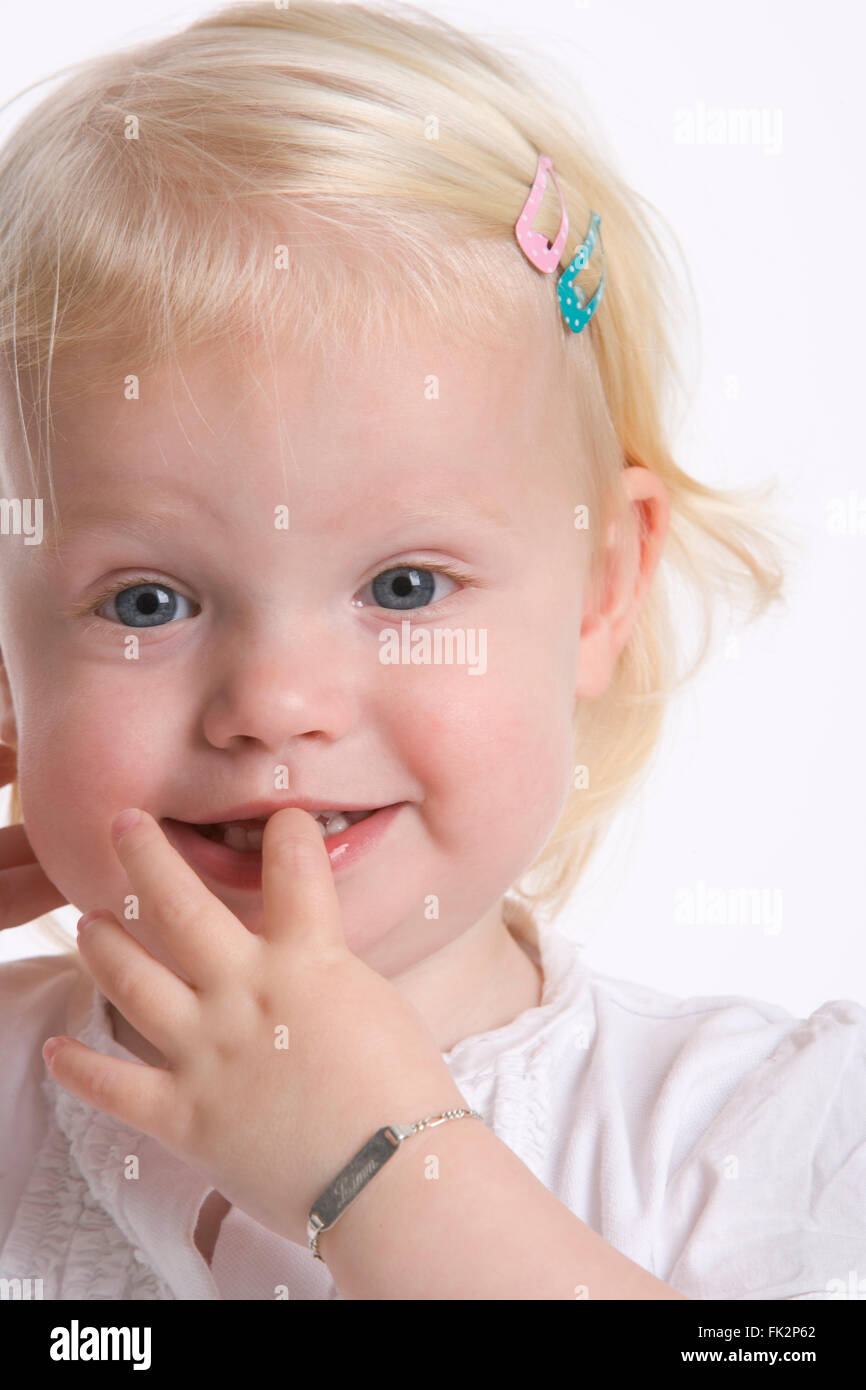 Porträt eines Mädchens blondes Kleinkind mit einem Finger In den Mund Stockfoto