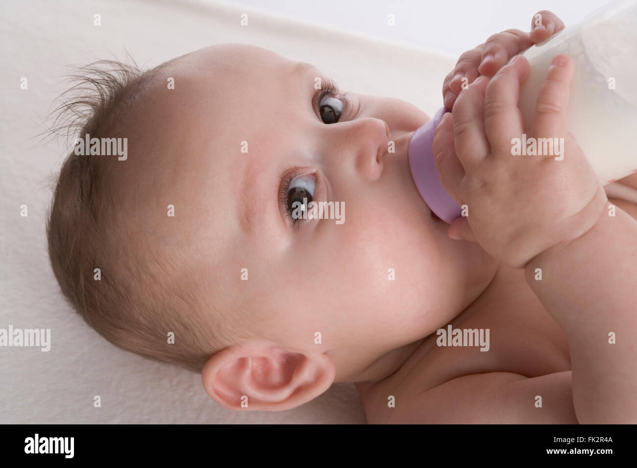 Babymädchen trinkt aus einer Babyflasche Stockfoto