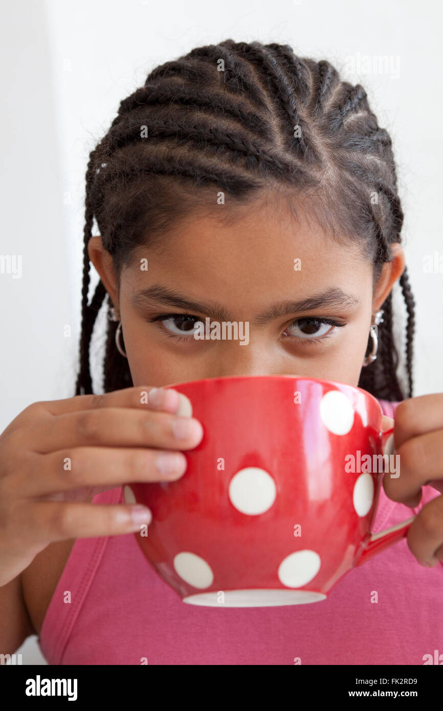 Teenagers Mädchen trinkt eine große Tasse Tee auf weißem Hintergrund Stockfoto