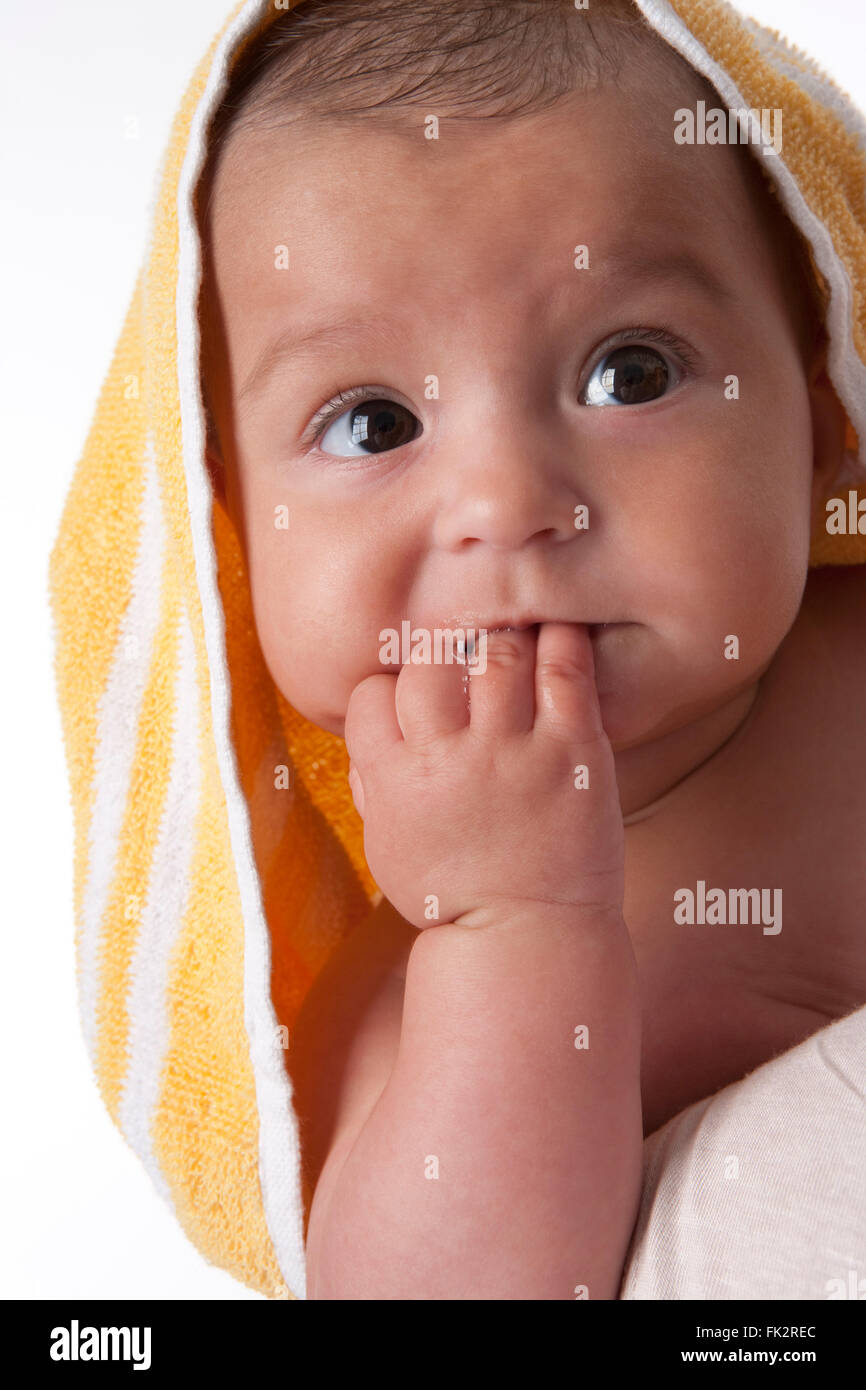 Porträt eines Babys eingewickelt in ein Handtuch auf weißem Hintergrund Stockfoto