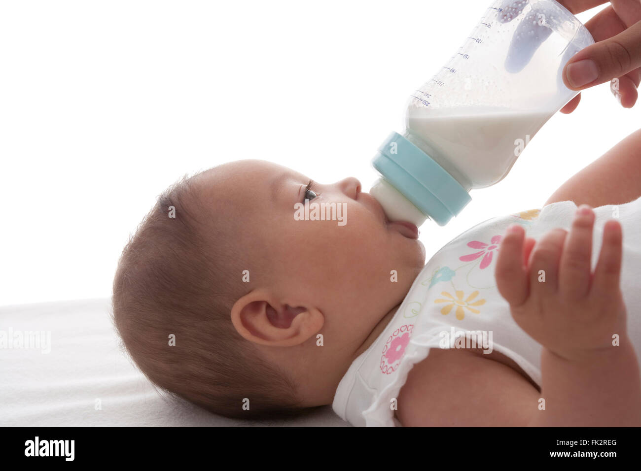 Baby bekommt Fläschchen auf weißem Hintergrund Stockfoto