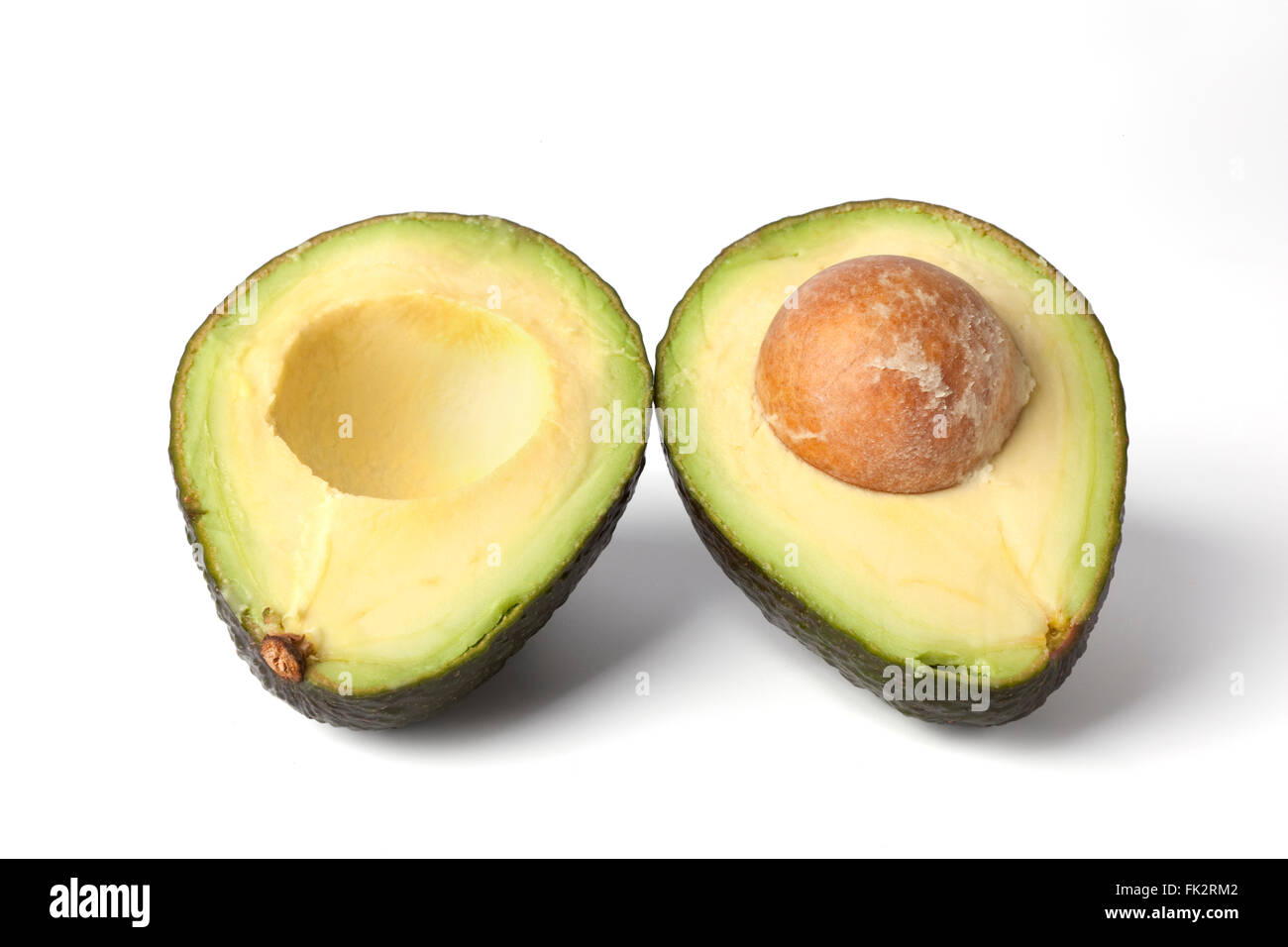 Frische Avocado schneiden Sie in zwei Hälften auf weißem Hintergrund Stockfoto