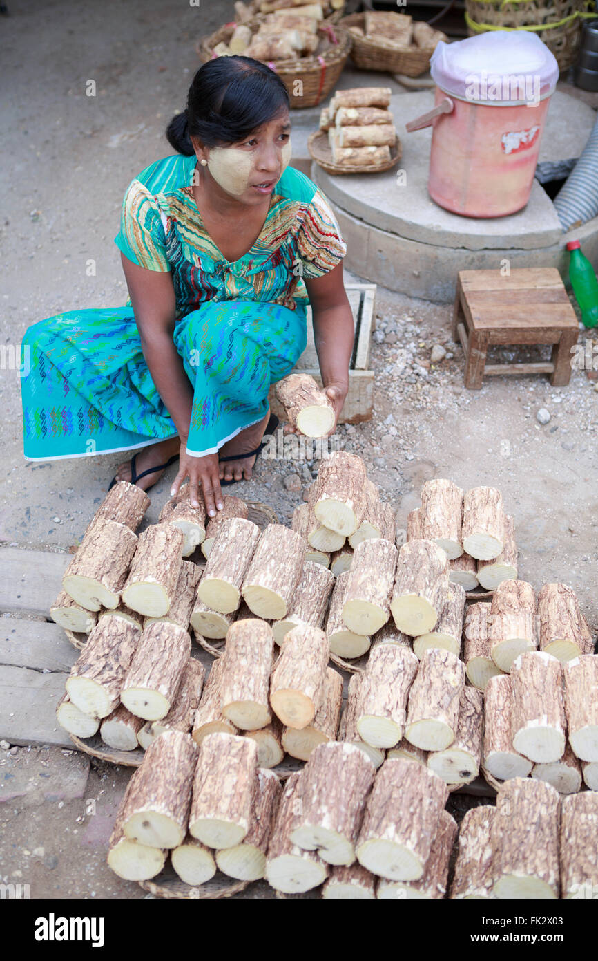 Eine Frau mit Thanaka paste im Gesicht Thanaka-Holz-Blöcke zu verkaufen Stockfoto