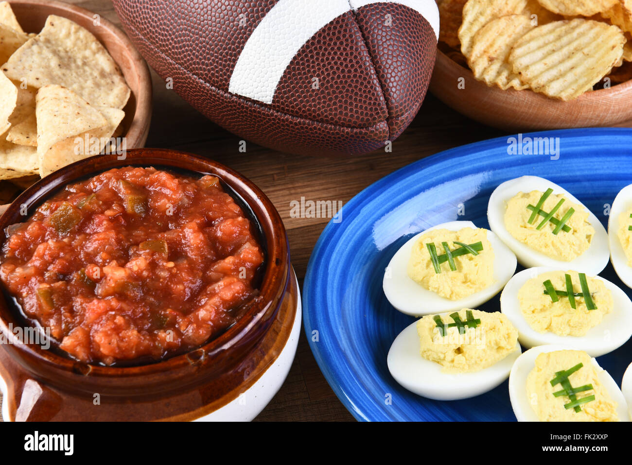 Nahaufnahme von Snacks für ein Fußballspiel, Chips, Salsa und deviled Eiern zu beobachten. Ideal für Super Bowl oder Playoff-thematische Projekte. Stockfoto