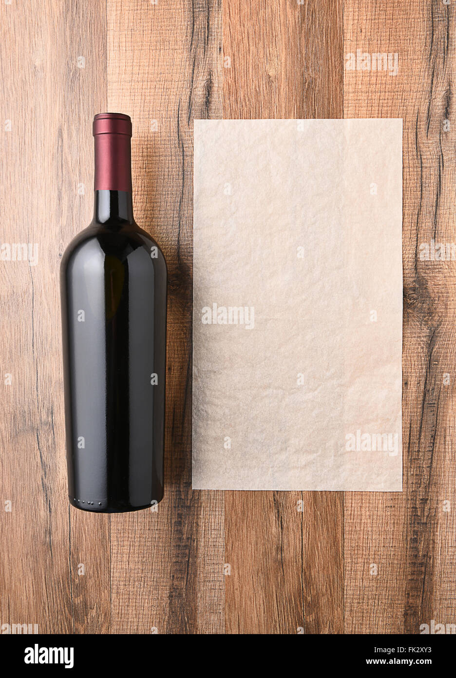 Draufsicht einer Weinflasche neben einem leeren Blatt Papier. Weinkarte-Konzept. Stockfoto