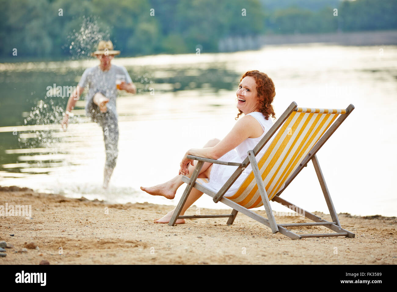 Glückliche Paare, die Spaß im Sommer am Strand eines Sees Stockfoto