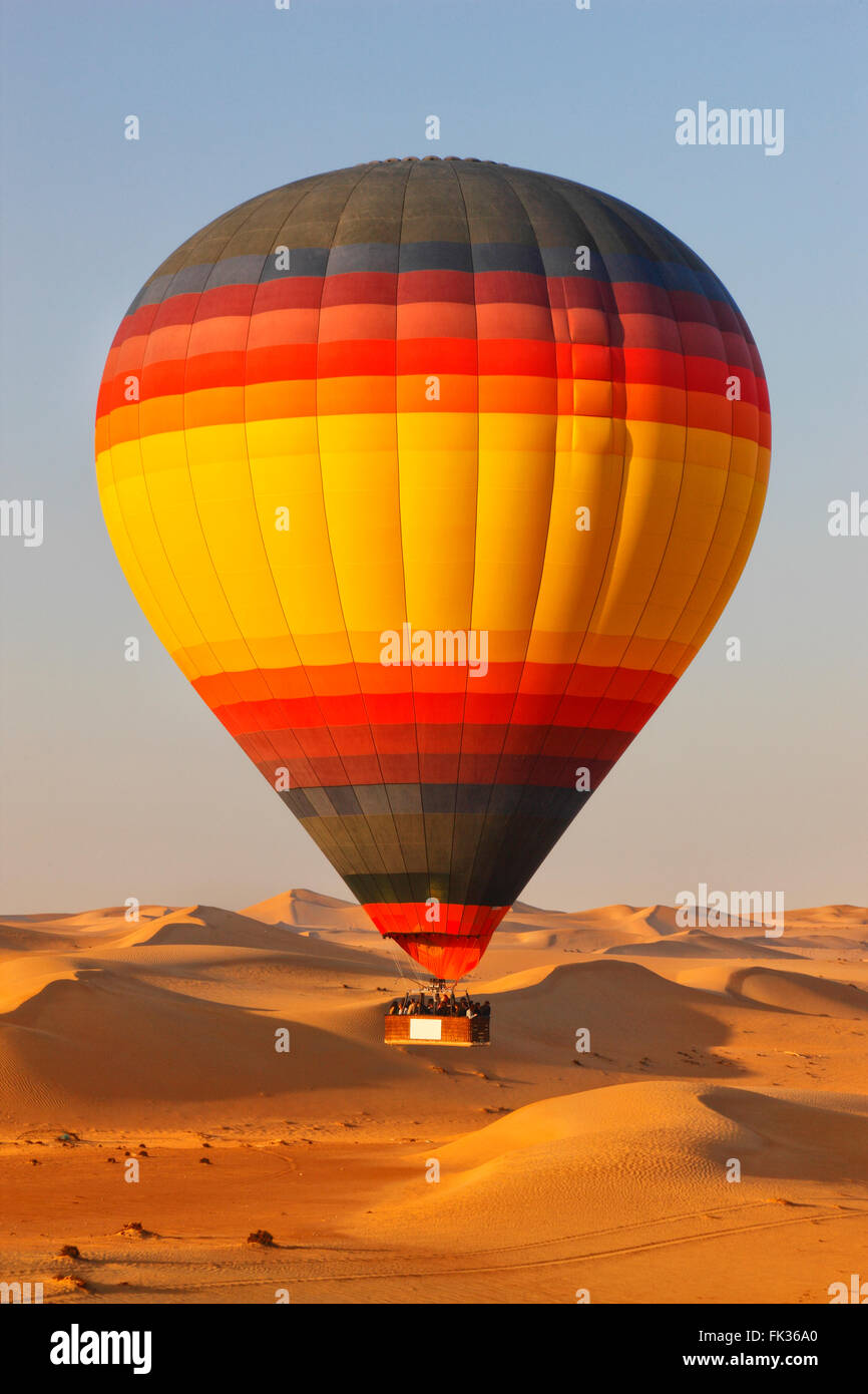 Bunter Heißluftballon fliegen über Dubai Wüste. Stockfoto