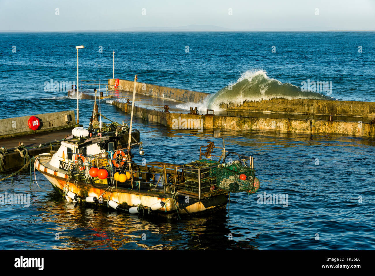 Große Welle stürzt über die Hafenmauer in John O' Groats, Caithness, Schottland, Vereinigtes Königreich. Stockfoto