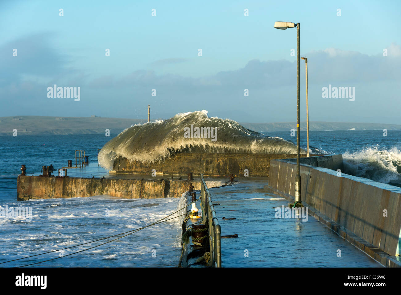 Große Welle stürzt über die Hafenmauer in John O' Groats, Caithness, Schottland, Vereinigtes Königreich. Stockfoto