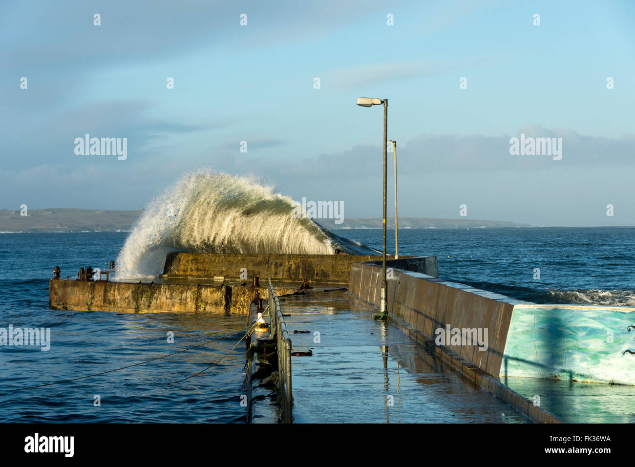 Große Welle stürzt über die Hafenmauer in John O' Groats, Caithness, Schottland, Vereinigtes Königreich. Stockfoto