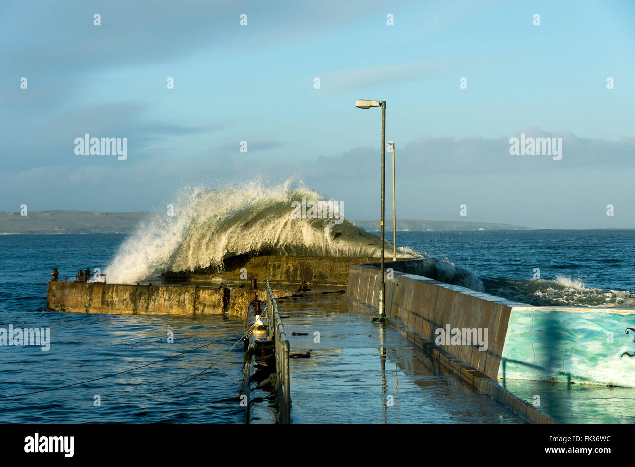 Große Welle stürzt über die Hafenmauer in John O' Groats, Caithness, Schottland, Vereinigtes Königreich. Stockfoto