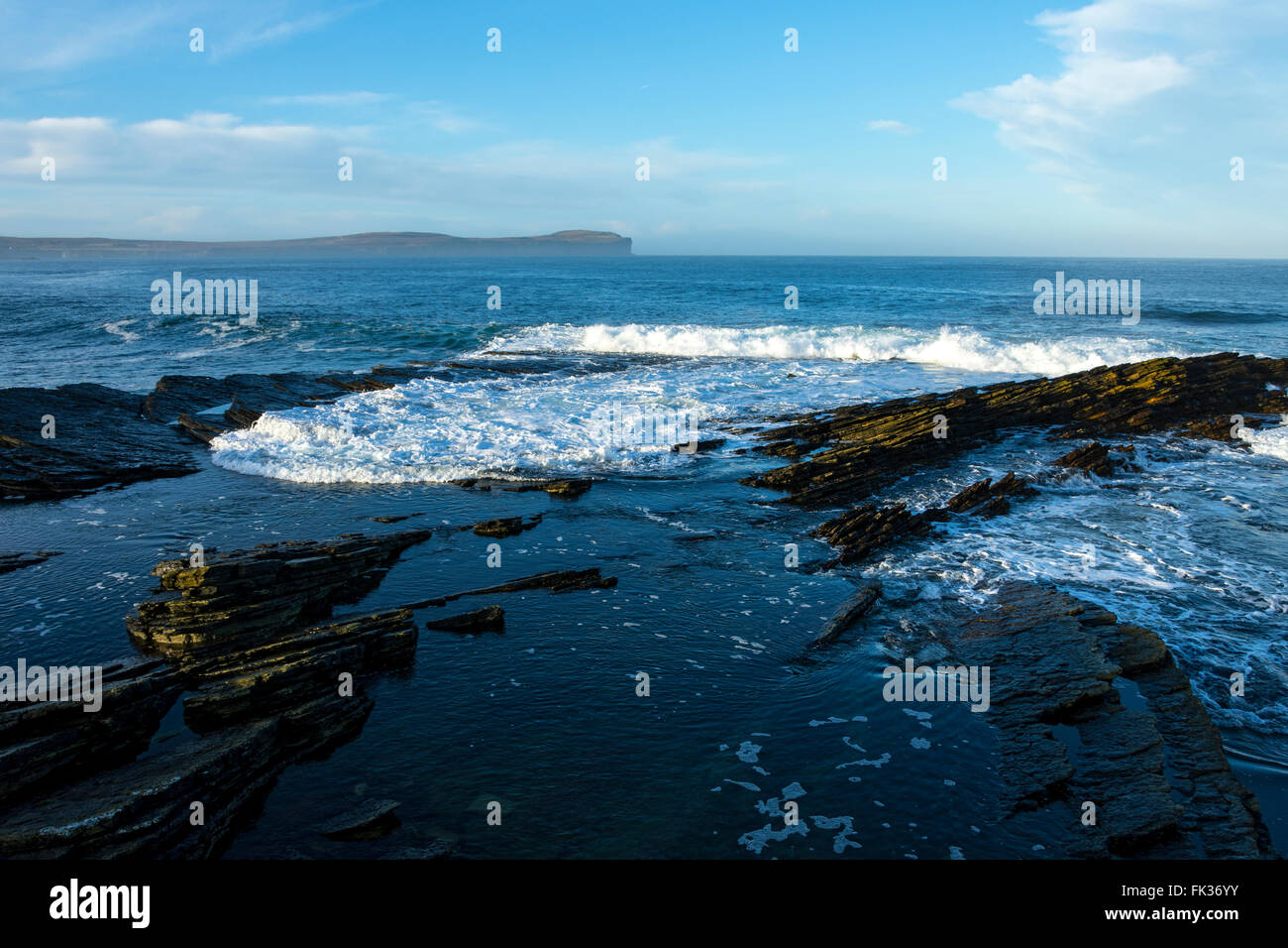 Felsen und Wellen die Küsten-Pfad in der Nähe von Scarfskerry, Caithness, Schottland, UK.  In der Ferne ist Dunnet Head. Stockfoto