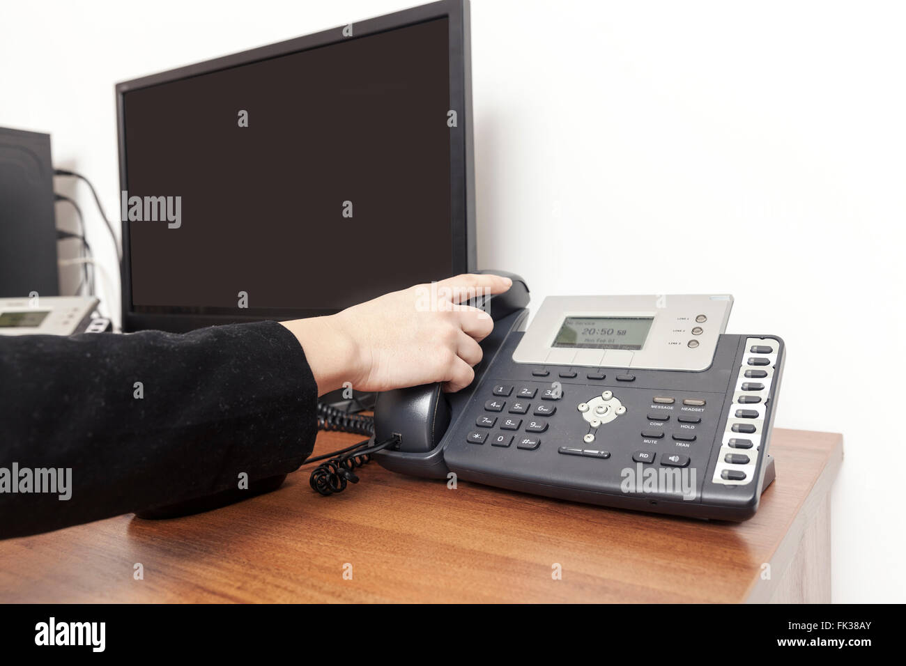 Hand auf das Telefon im Arbeitsbereich Stockfoto