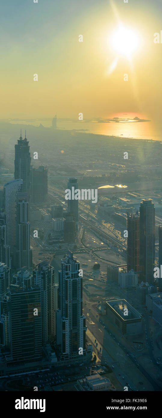 Wolkenkratzer während des Sonnenuntergangs in Dubai, Reflexlicht, vertikales panorama Stockfoto