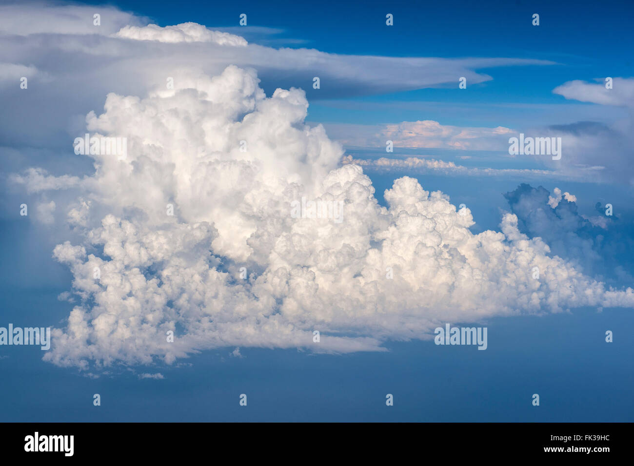 Eine schöne weiße Wolke mit einer bizarren Form in einem blauen Himmel fotografiert aus dem Flugzeugfenster auf einem Flug in Italien und Spanien Stockfoto