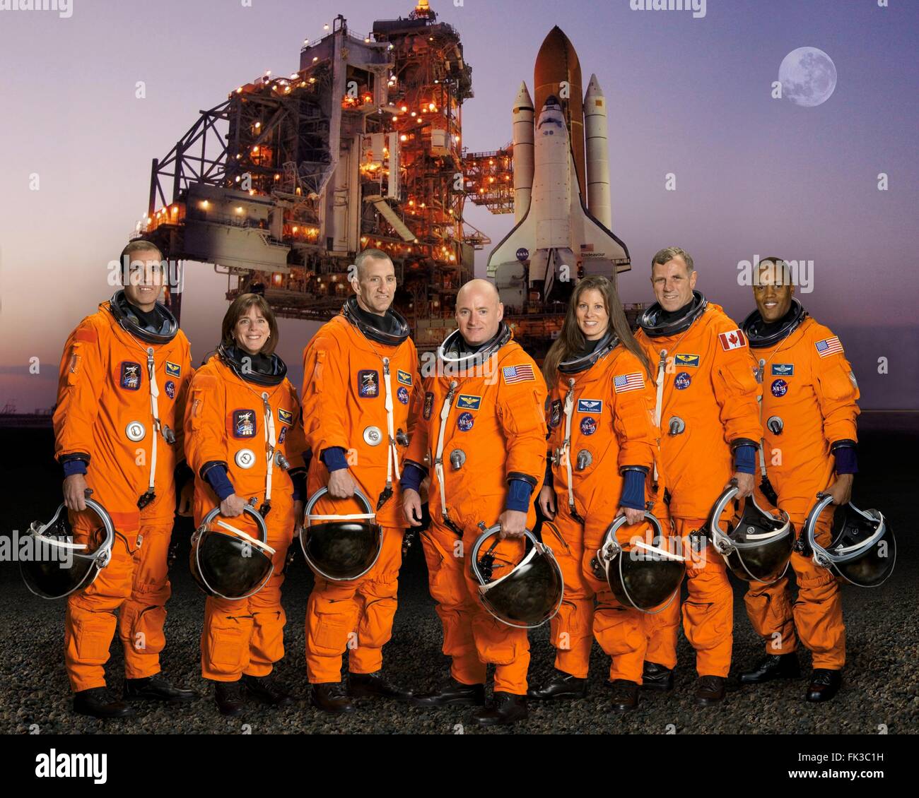 Gruppenbild der STS-118 Space Shuttle Crew Astronauten in orange Start und Eintrag Anzügen am Johnson Space Center 5. April 2006 in Houston, Texas.  Die Crew von L-r: Astronauten Rick Mastracchio, Barbara Morgan, Charles Hobaugh, Scott Kelly, Tracy Caldwell, Dave Williams, und Alvin Drew Jr. Stockfoto