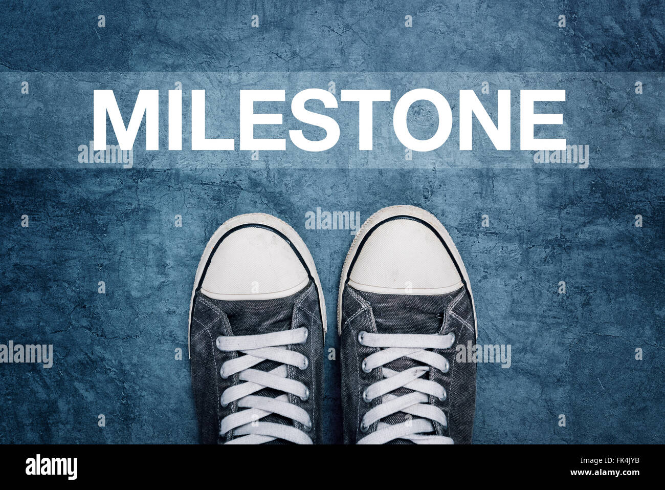 Junger Mann auf der Straße, Meilenstein Kennzeichnung auf Straße, Konzept der Durchbruch-Leistung Stockfoto